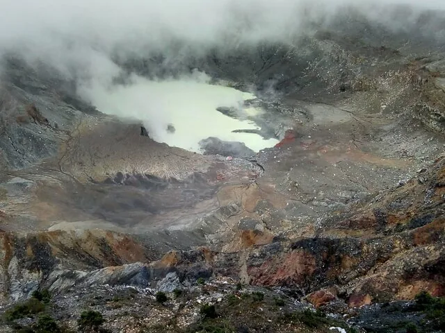 A wide view of the Poas Volcano crater with a cloudy acid lake