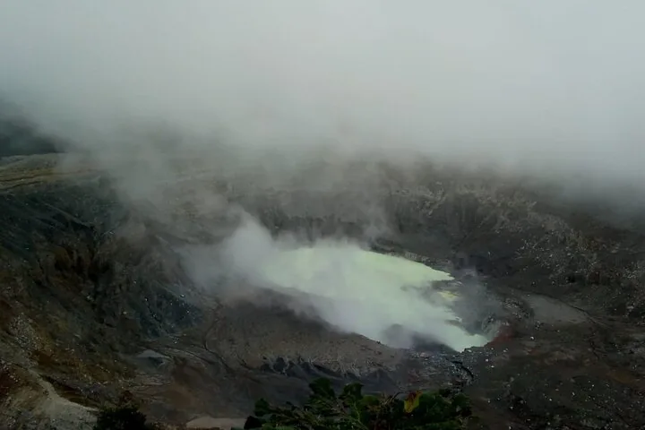 Fog obscures the view of the large Poas Volcano crater and acid lake